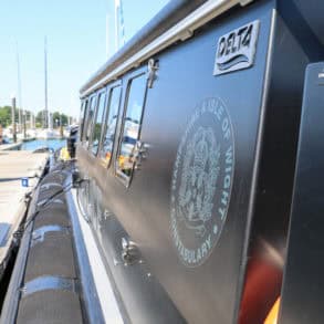 Police officers walking towards docked police defender rhib