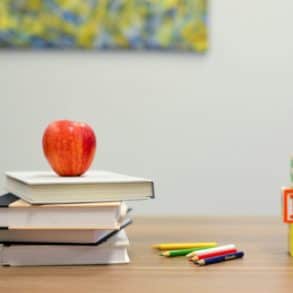 Books and apple and ABC blocks on a school desk