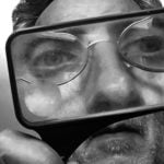 Man looking through magnifying glass