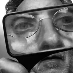 Man looking through magnifying glass