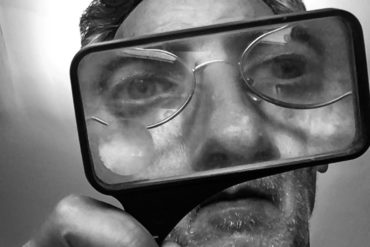 Man looking through magnifying glass