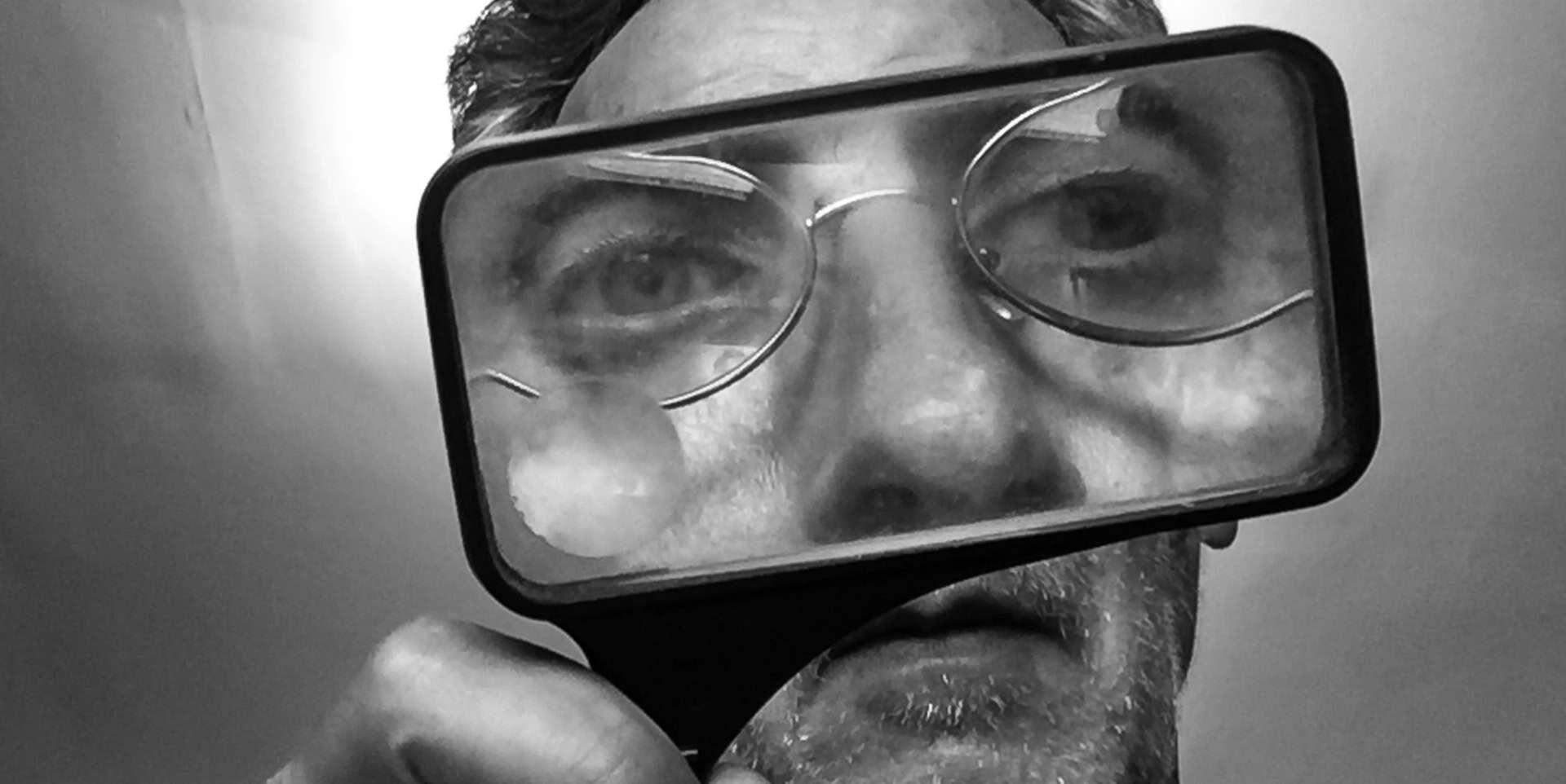 Man looking through magnifying glass