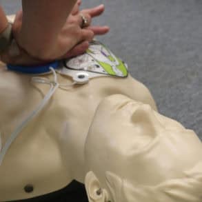 Person doing CPR on plastic dummy