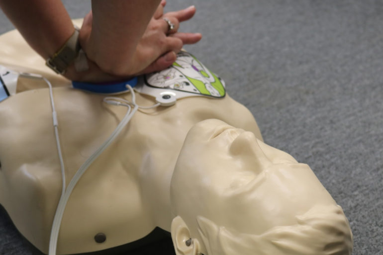 Person doing CPR on plastic dummy