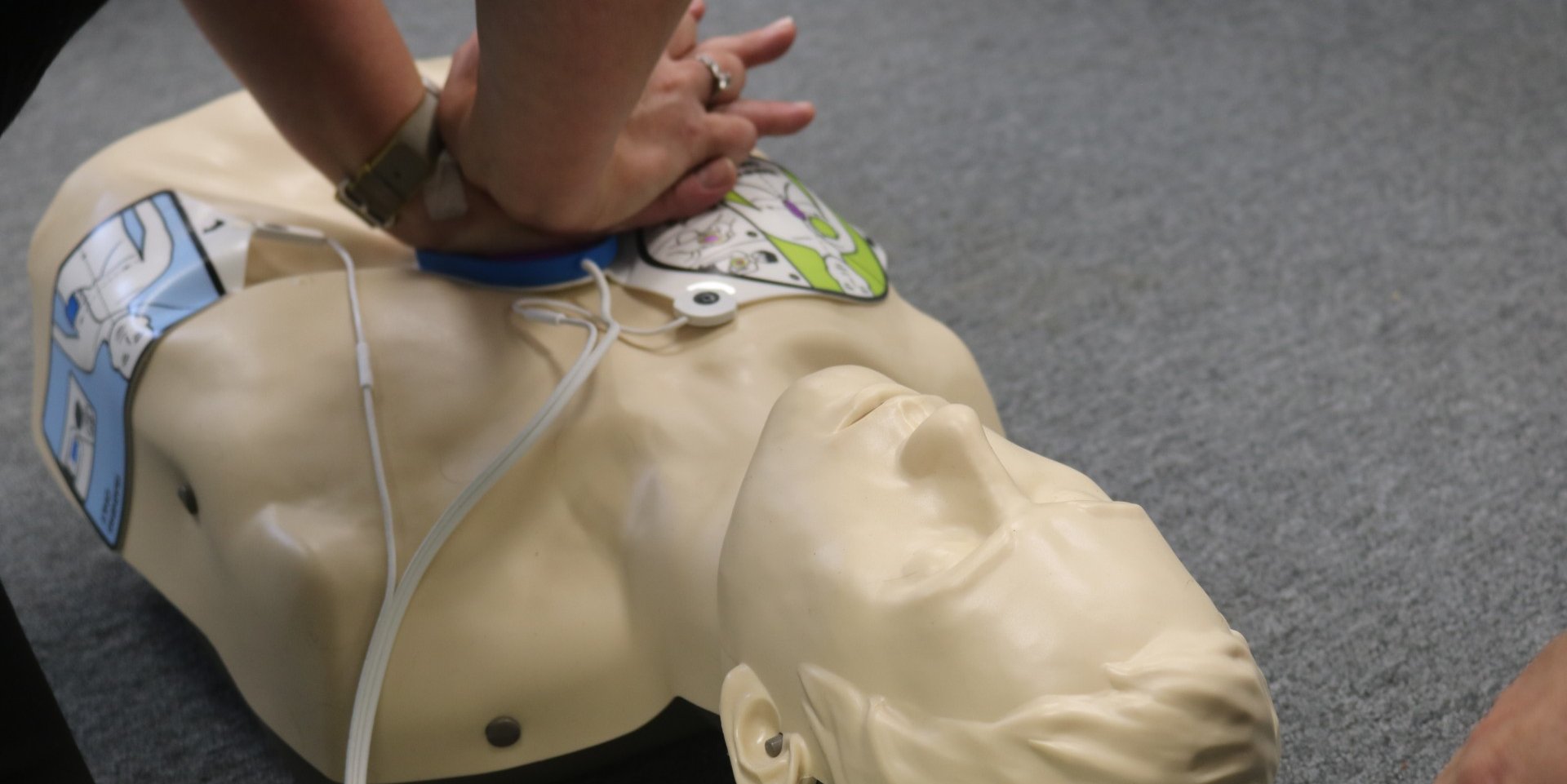 Person doing CPR on plastic dummy