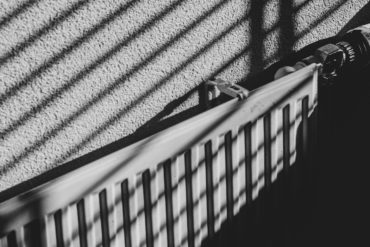 black and white image of a radiator with shadow of venetian blinds