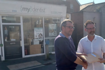 ieuan jehu handing over petition to richard quigley MP outside mydentist Freshwater