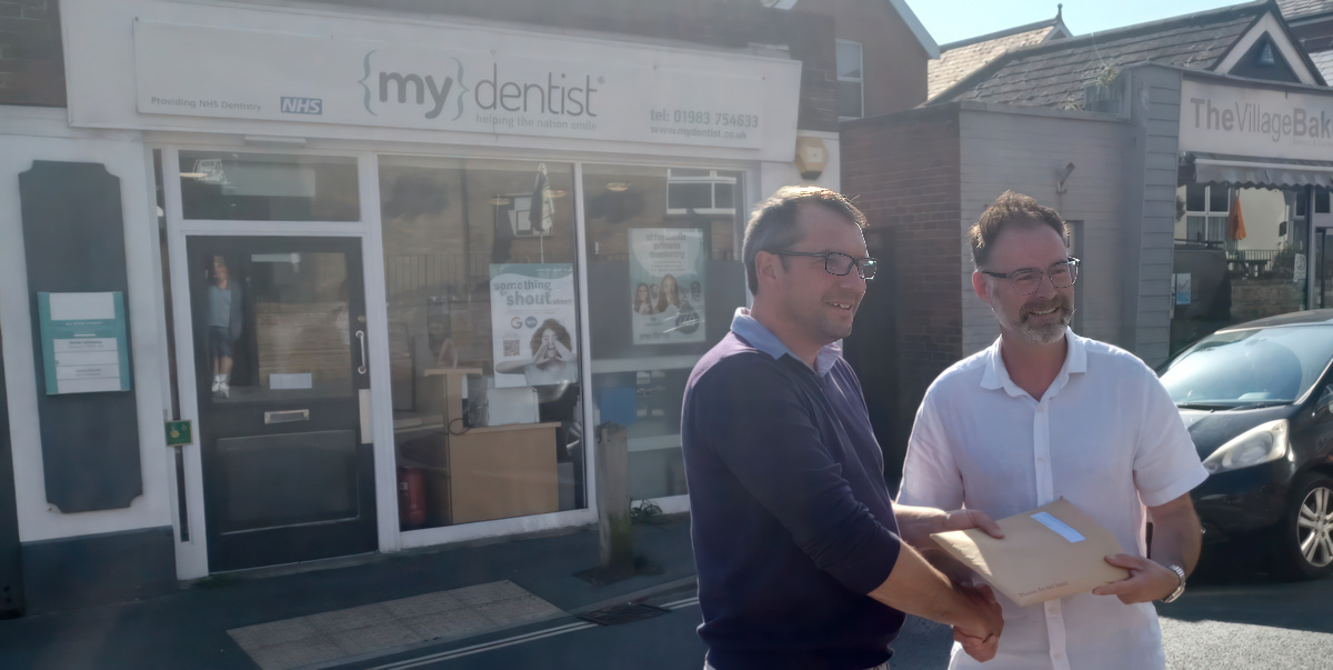 ieuan jehu handing over petition to richard quigley MP outside mydentist Freshwater