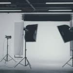 Black and white image of a photography studio with lights and backdrops