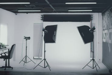 Black and white image of a photography studio with lights and backdrops