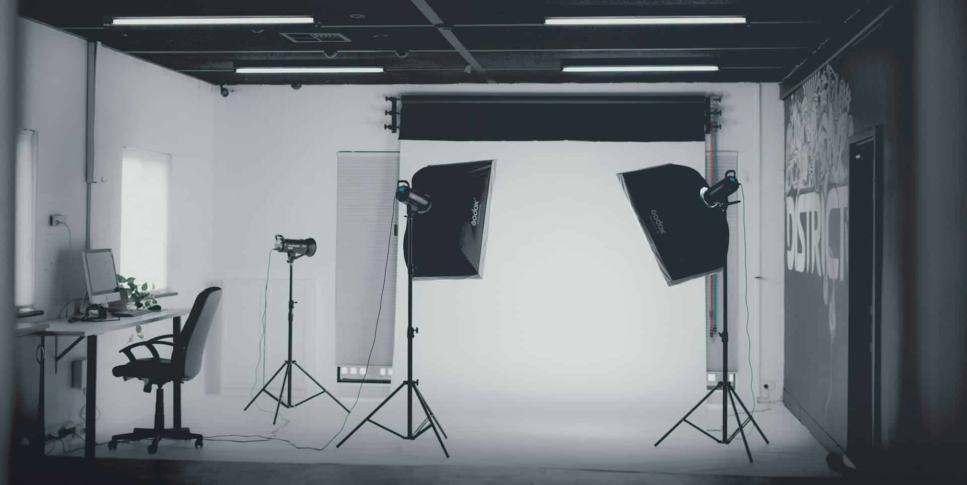 Black and white image of a photography studio with lights and backdrops