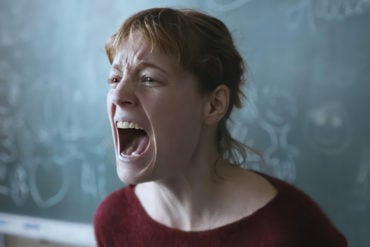 scene from The Teachers' Lounge showing a teacher standing by the blackboard screaming