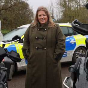 Donna Jones by police motorbikes and patrol car