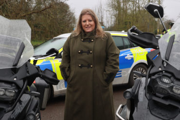 Donna Jones by police motorbikes and patrol car