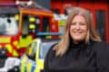 Donna Jones standing in front of a police car and fire engine