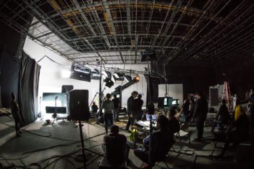 Inside a film studio, with lots of cameras and lighting