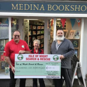 Dean Terrett, Paul Armfield and Jennifer Johnston standing outside the bookshop with a giant cheque