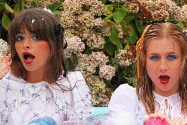 Band members sitting in an inflatable pool filled with bubble bath