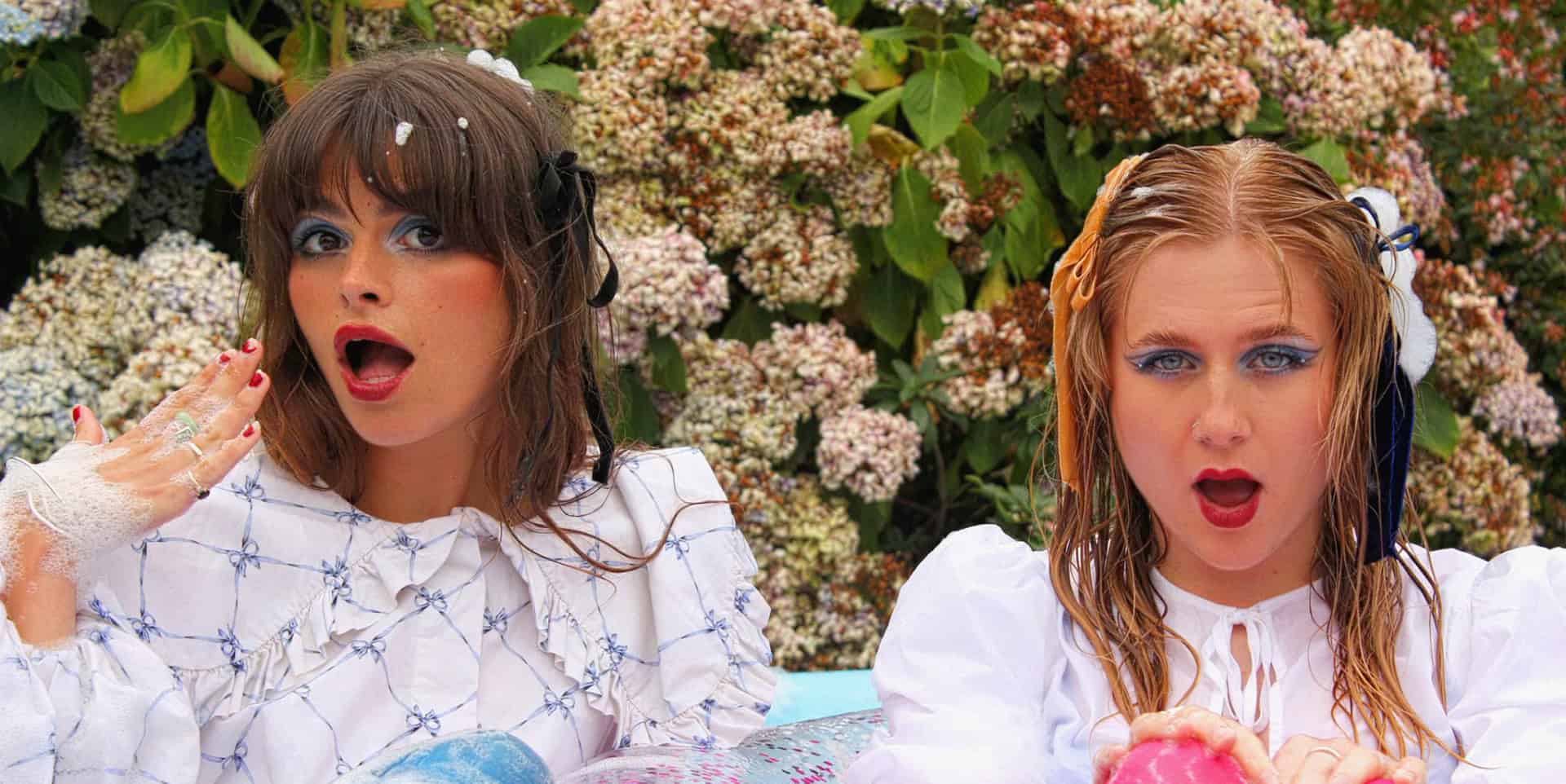 Band members sitting in an inflatable pool filled with bubble bath