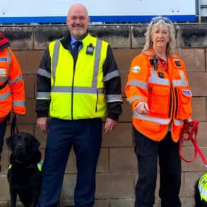 WightSAR Trainee Search Dog handler Catherine Fitton with Ginny, Wightlink Island Port Operations Manager Martin Gulliver and Trainee Search Dog handler Jasmine Light with Malli