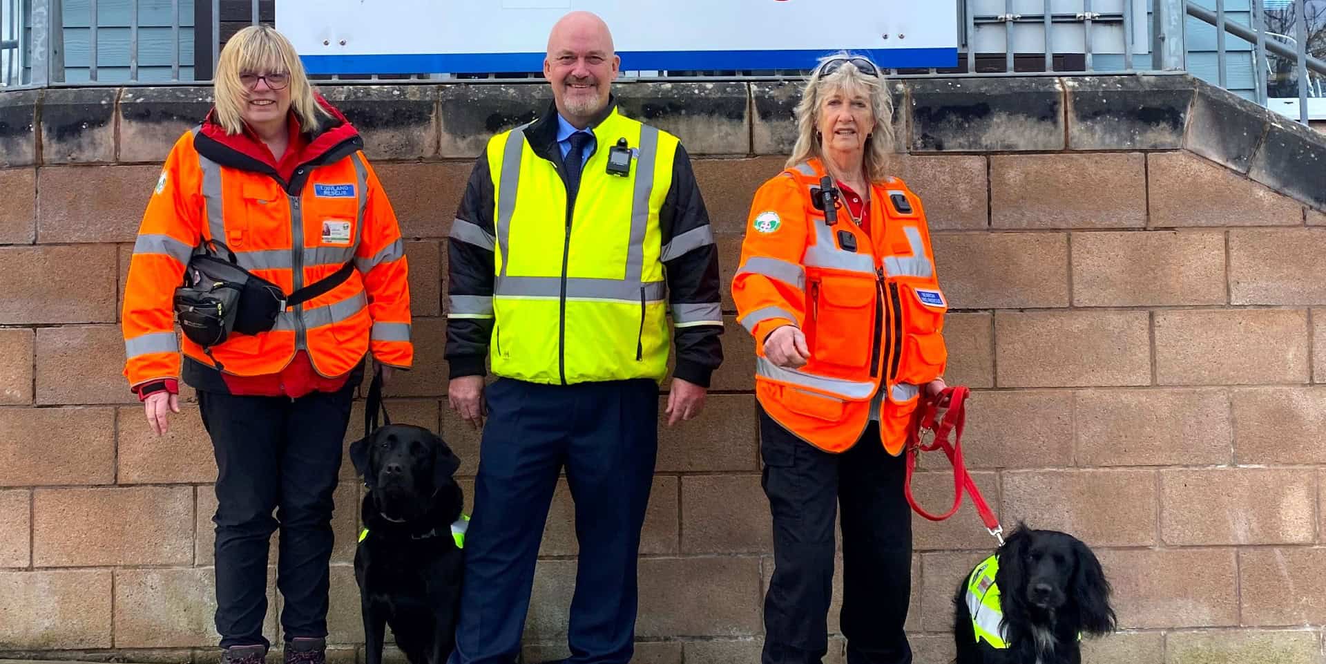 WightSAR Trainee Search Dog handler Catherine Fitton with Ginny, Wightlink Island Port Operations Manager Martin Gulliver and Trainee Search Dog handler Jasmine Light with Malli