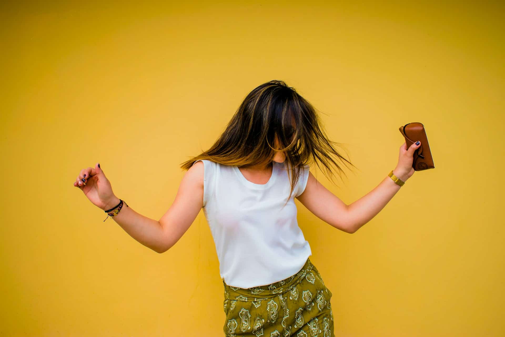 Teenage Girl dancing against a yellow background