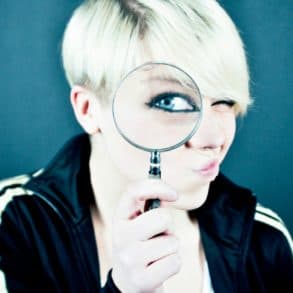 Young women looking through a magnifying glass