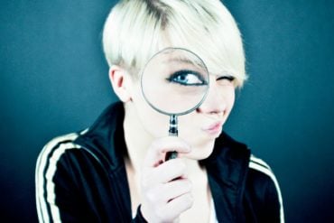 Young women looking through a magnifying glass