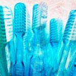 a bunch of blue tooth brushes in a cup