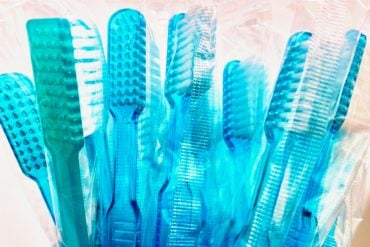 a bunch of blue tooth brushes in a cup