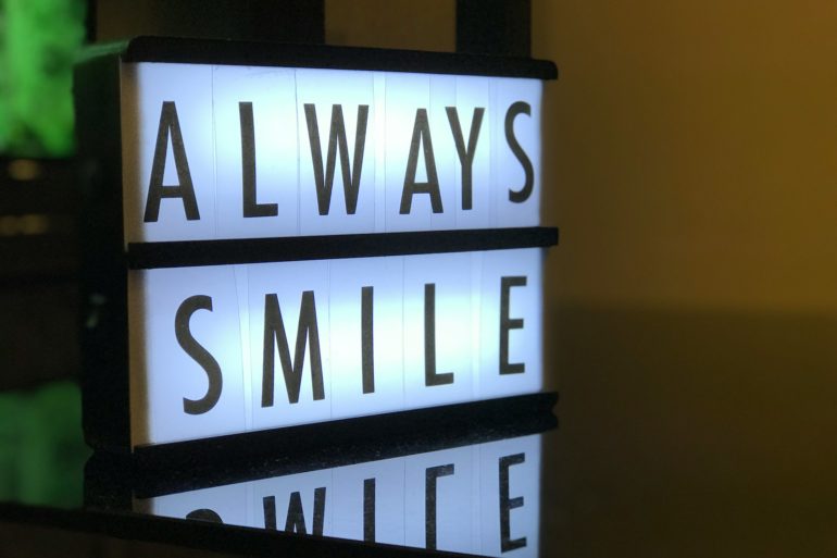 back lit sign saying 'always smile'