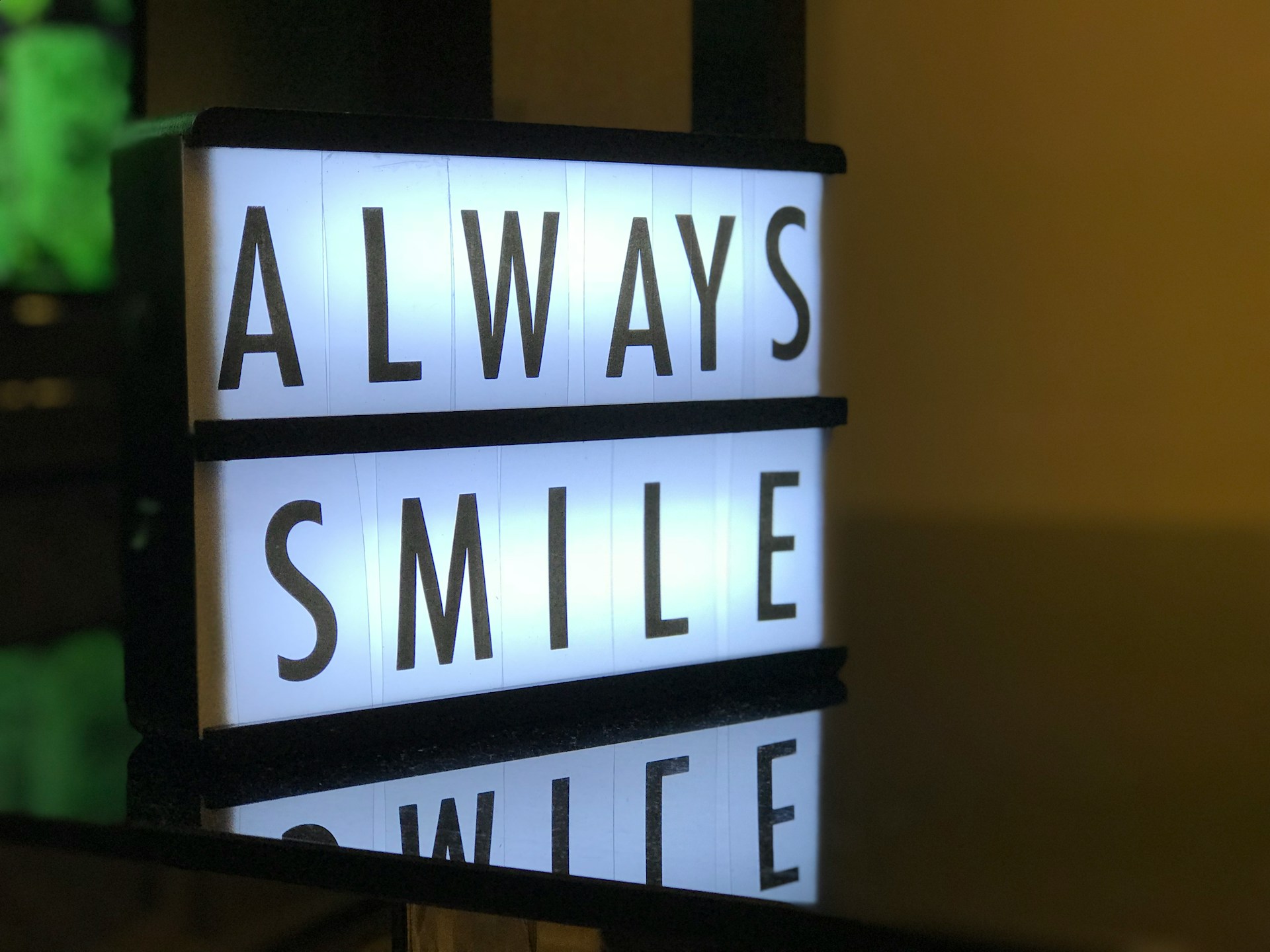 back lit sign saying 'always smile'