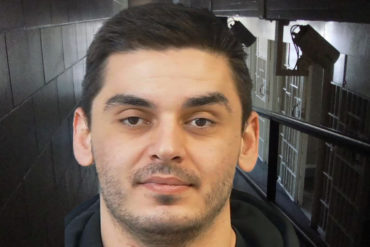 Mugshot of Gezim Bajrami with jail corridor in background