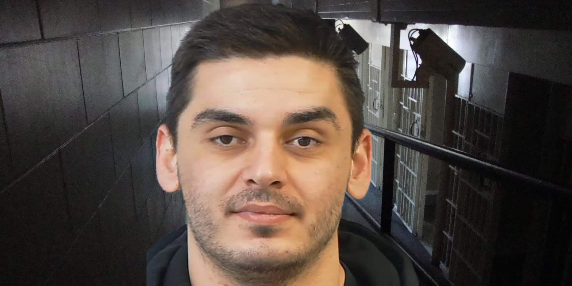 Mugshot of Gezim Bajrami with jail corridor in background