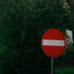 no entry sign with woodland behind it