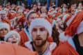 Lots of people dressed up in santa outfits taking part in a charity run