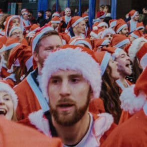 Lots of people dressed up in santa outfits taking part in a charity run