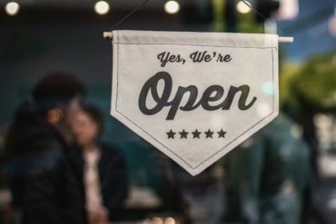 A 'yes we are open' sign on a shop door