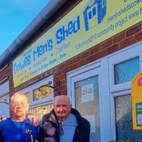 Members of Cowes Men's Shed outside with the newly installed defibrilator