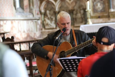 Man playing the guitar at All Saint's Church in Ryde