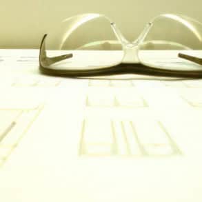 Pair of safety glasses sitting on blueprints for building