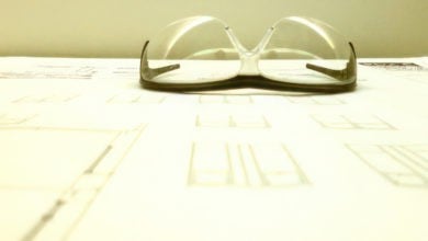 Pair of safety glasses sitting on blueprints for building