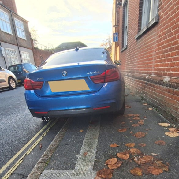 Car parked on the pavement blocking access with wheelchair