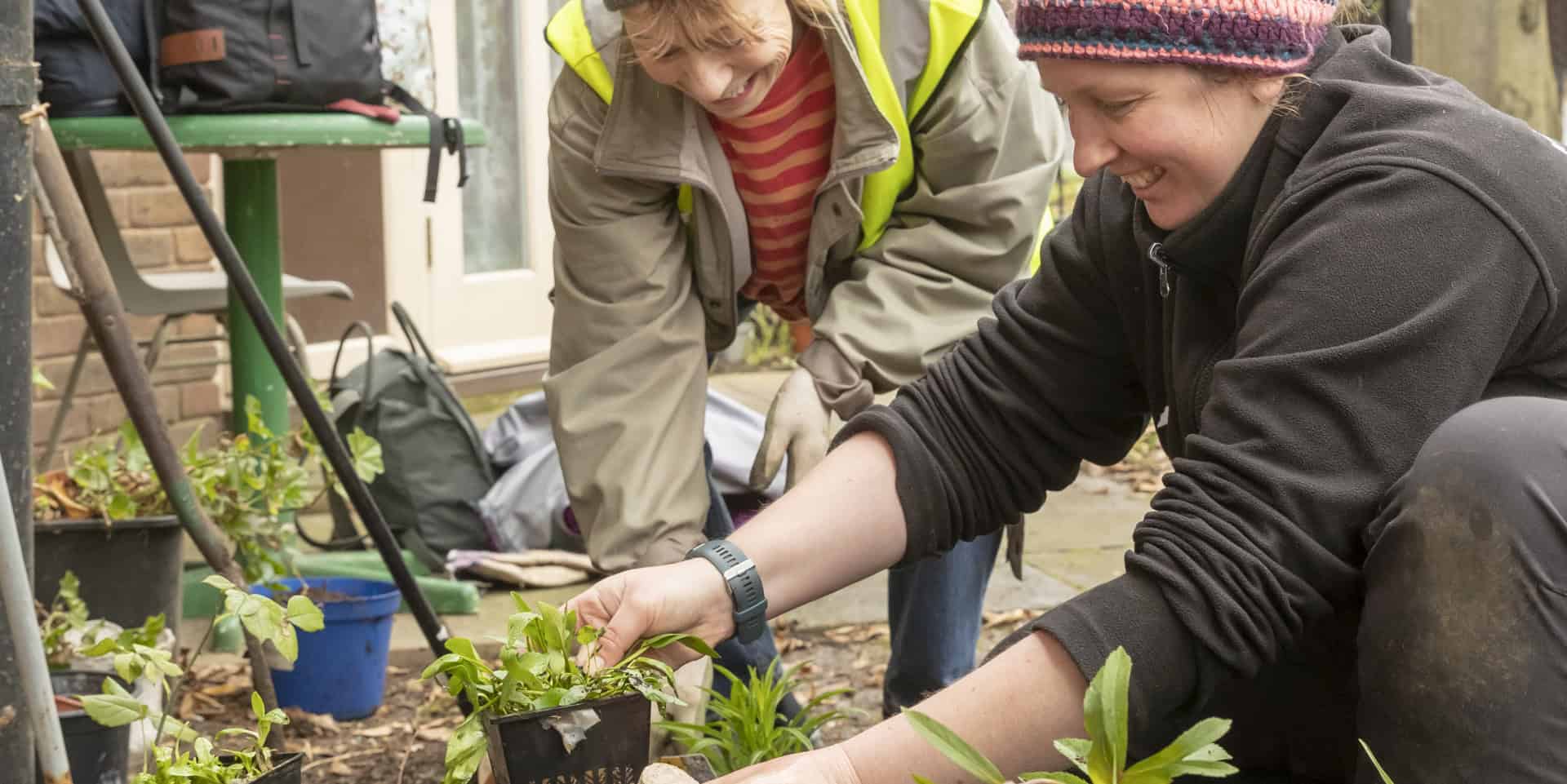 Two women doing some planting as part of a community gardening scheme