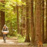 Couple cycling through woodland