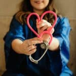 Nurse holding stethoscope with rubber chord in shape of heart