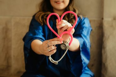 Nurse holding stethoscope with rubber chord in shape of heart