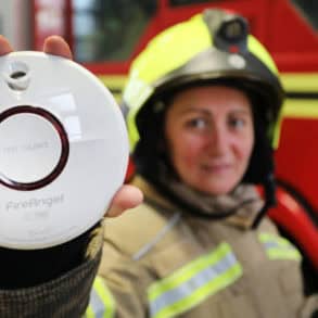 Firefighter holding a Smoke Alarm