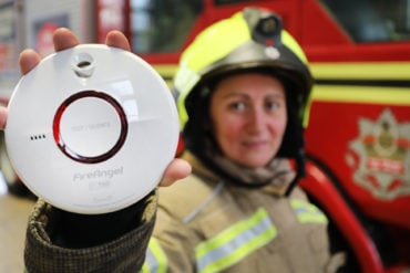 Firefighter holding a Smoke Alarm