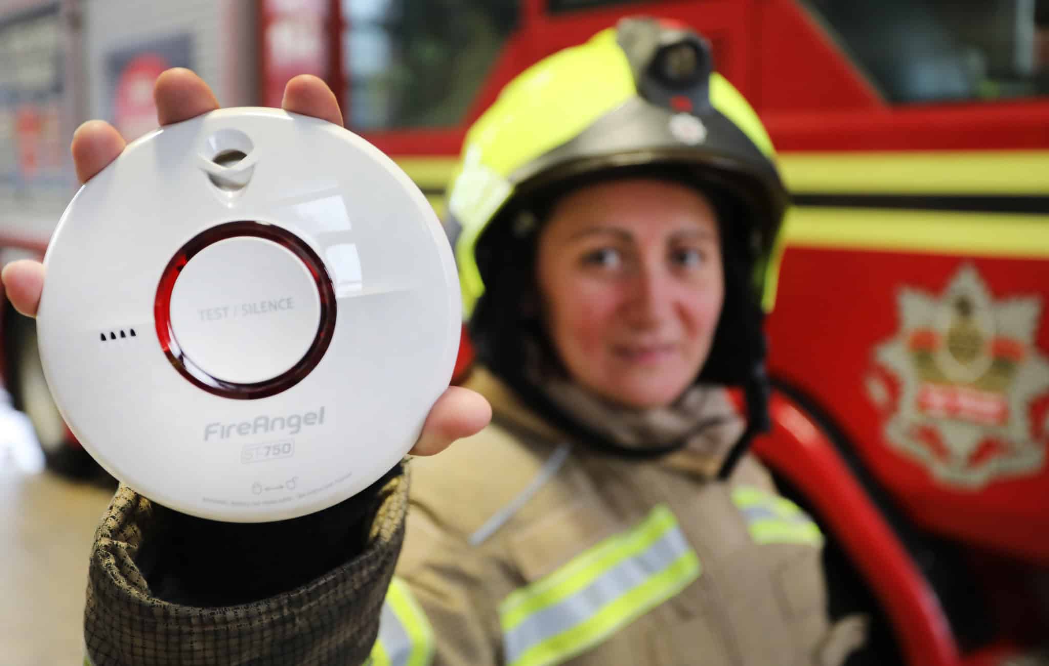 Firefighter holding a Smoke Alarm